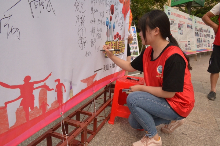 志愿者在签名墙上签名.jpg